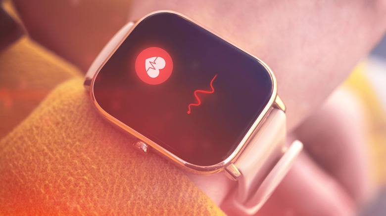 Close-up smart watch with heart rate icon.