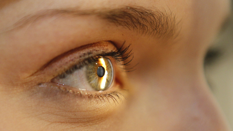 Close-up of light reflecting off a woman's eyeball 