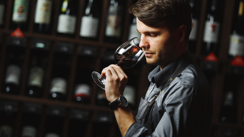 Man sniffing glass of red wine