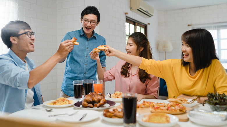 Friends together enjoying pizza.