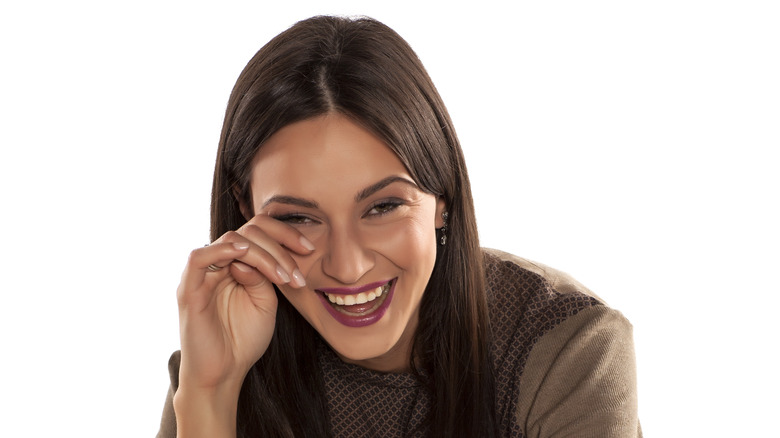 Woman wiping eyes from crying 