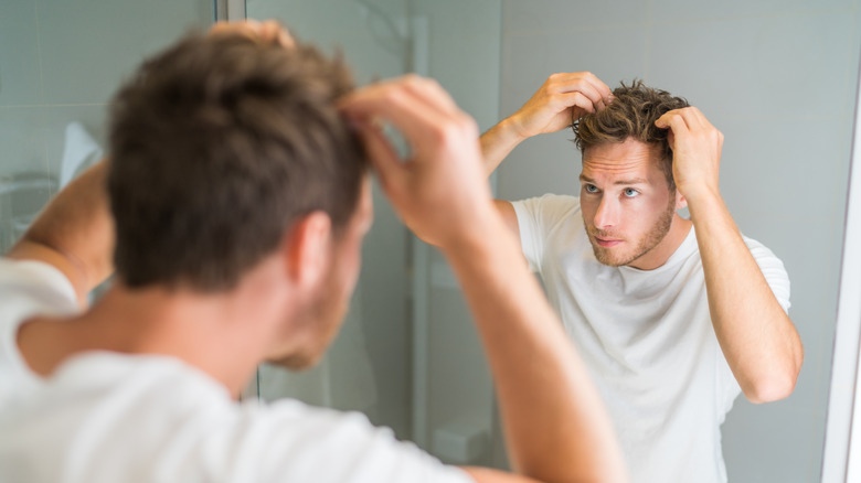 Man looking in mirror for hairloss
