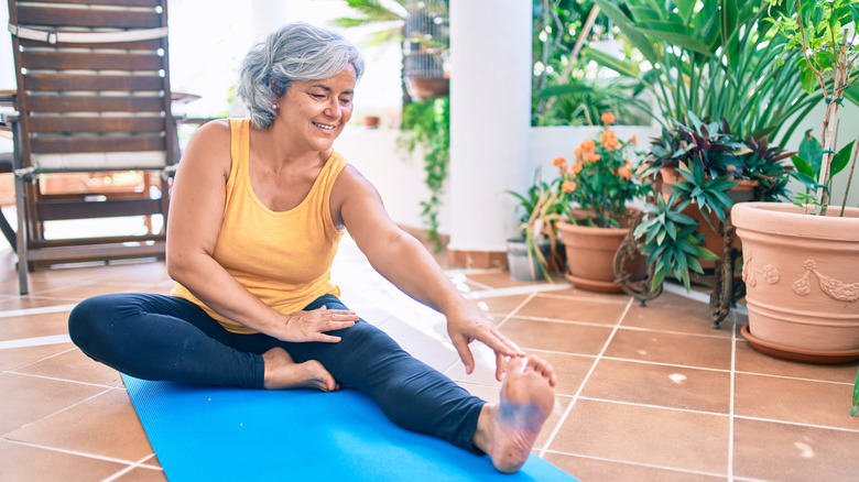 senior woman stretching on mat