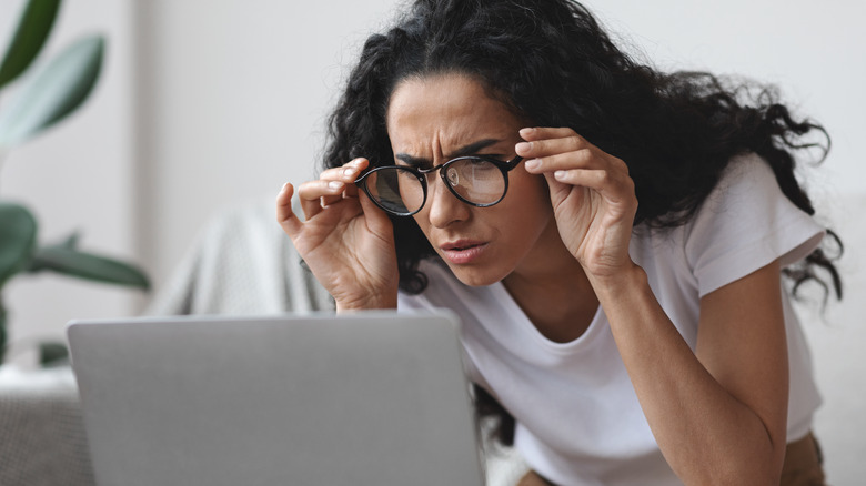 woman squinting at laptop