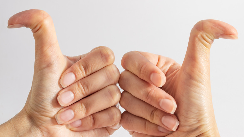 Two hands making thumbs-up gesture