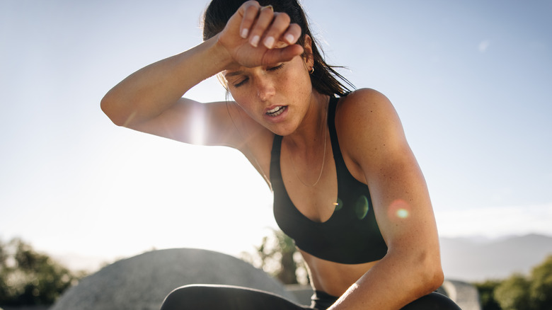 woman exhausted in the sun in workout clothes