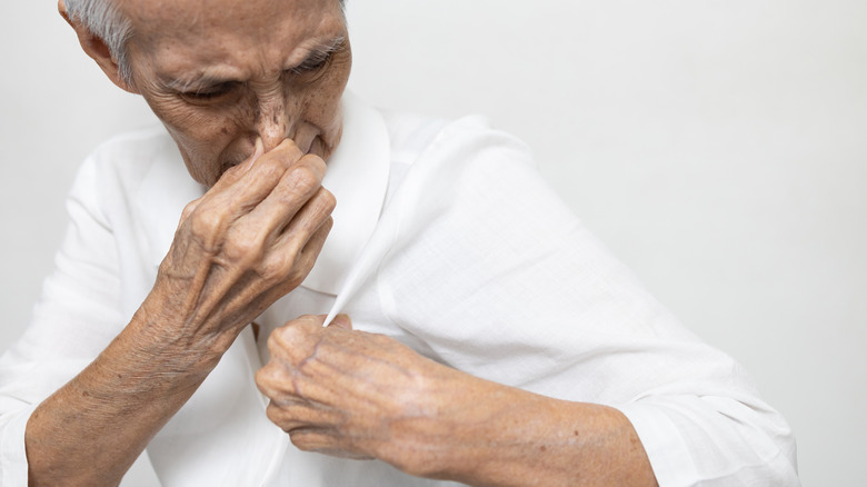 Elderly man pinching his nose
