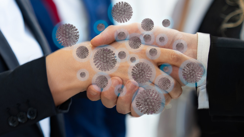 Image of two people shaking hands overlaid with germs
