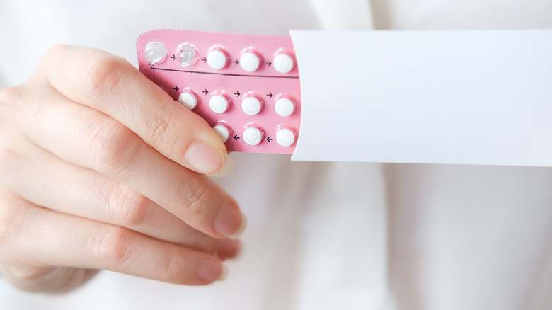 A woman holds a package of birth control pills