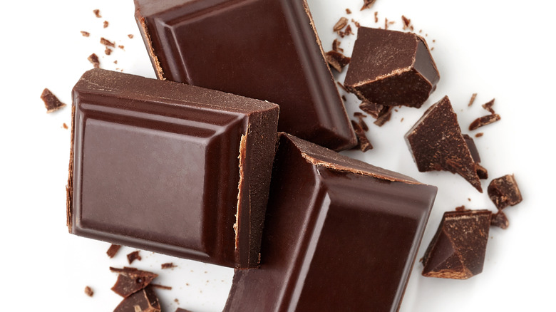 Three dark chocolate pieces isolated on white background.