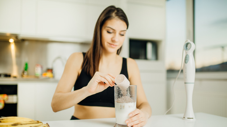 Woman with blender making protein shake