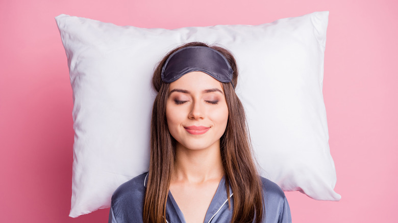 Smiling woman sleeping on pillow 