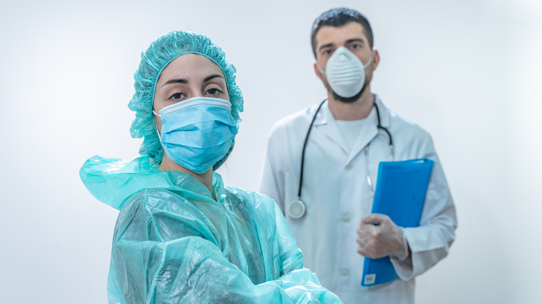 Two doctors in masks and scrubs