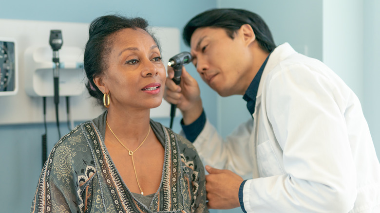 Doctor examining patient's ear