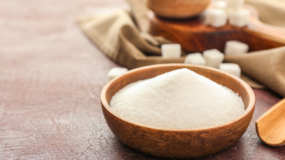 Bowl of sugar with sugar cubes in background