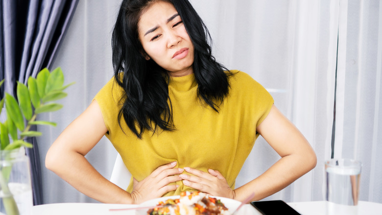 Woman having stomach pain while dining out