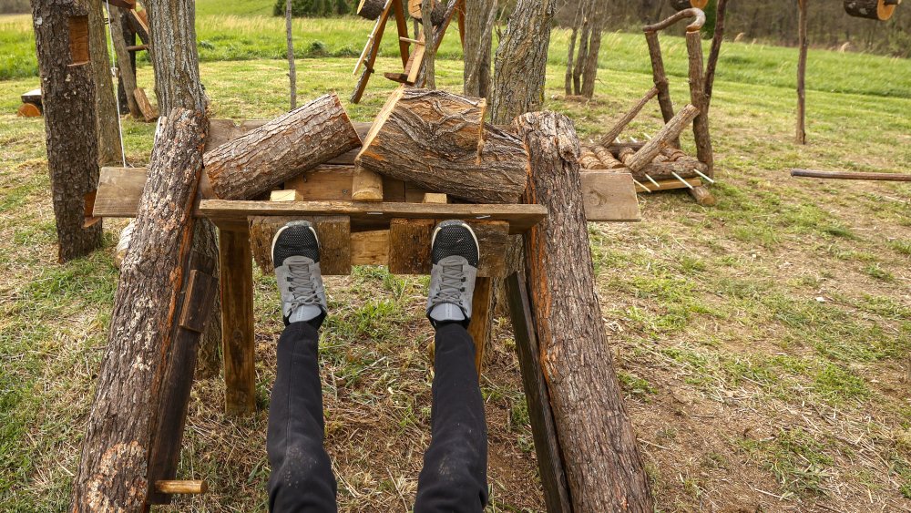 Man lifting weights outdoors with his legs