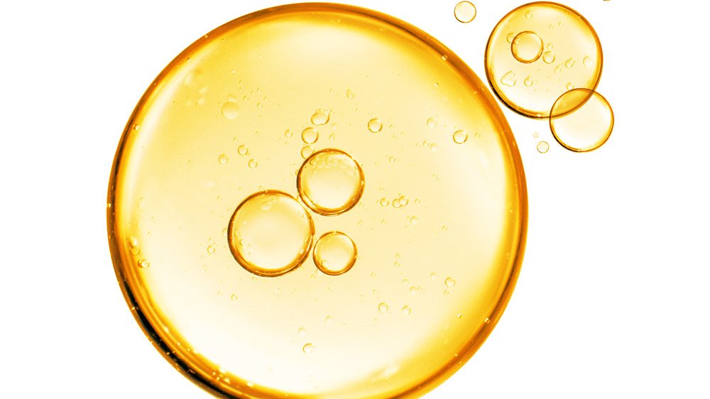 yellow and gold bubbles of oil on a white background 