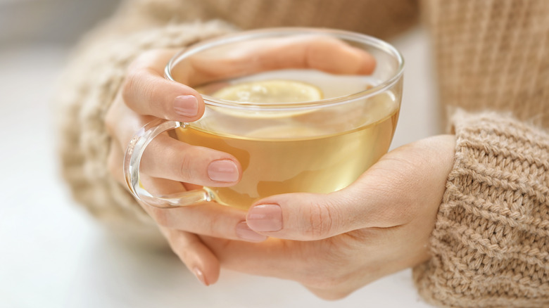 woman holds cup of herbal tea