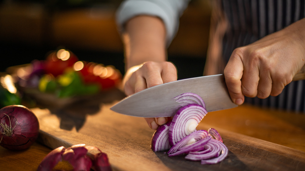Chef slicing red onions