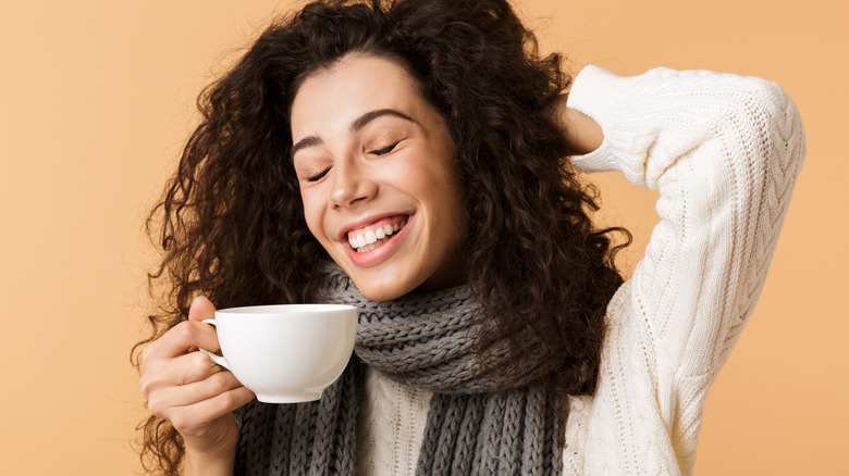 Woman drinking tea wearing scarf