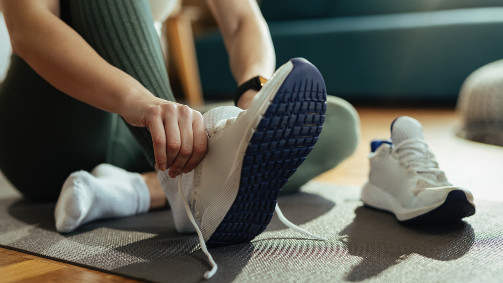 woman putting on sneakers