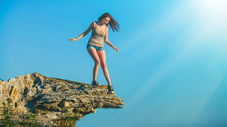 Woman standing on edge of a rock cliff 