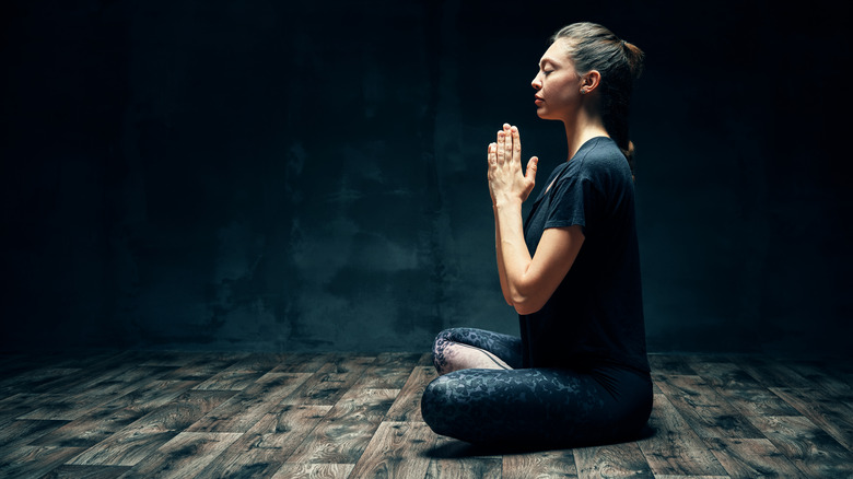 woman meditating in dark room
