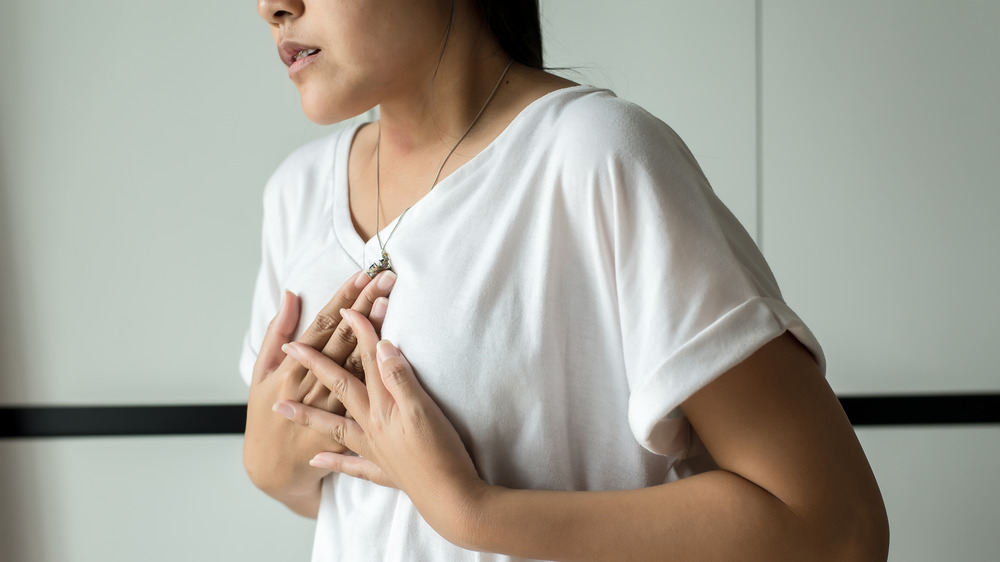 Woman holding her chest in discomfort