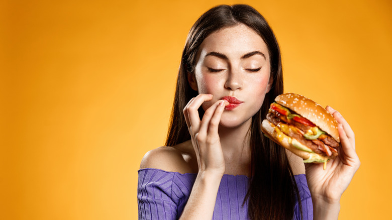 A woman eats a burger