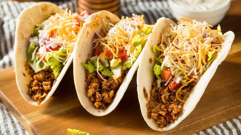 a close up of three tacos on a tre