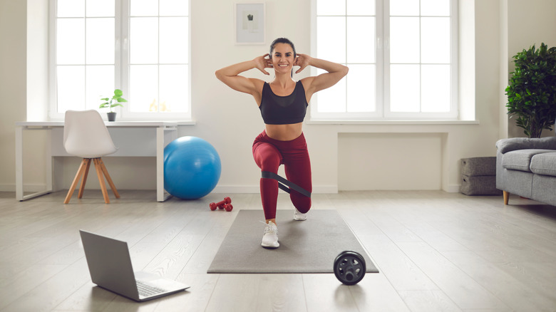 A woman does lunges in her home