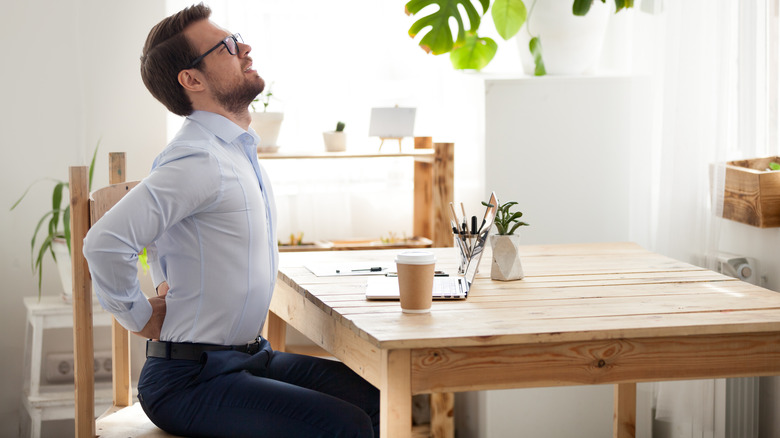 man in pain sitting at desk