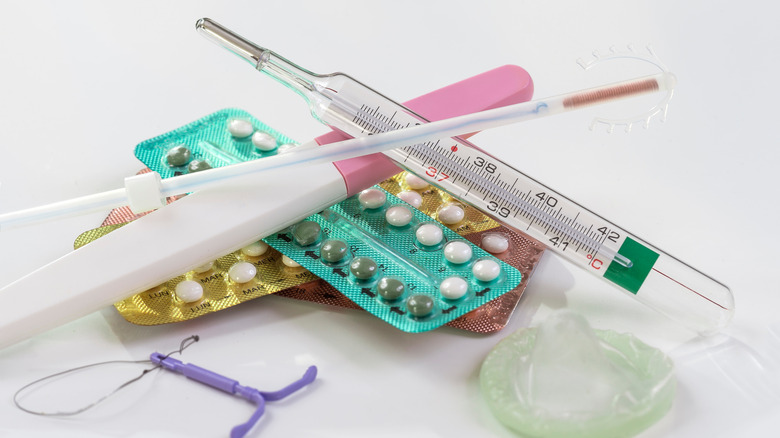 Different types of birth control methods on white background