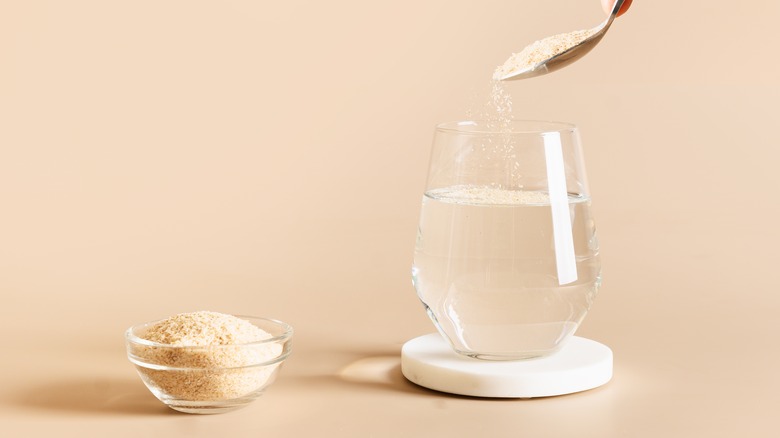 Person stirring a fiber supplement into a glass of water