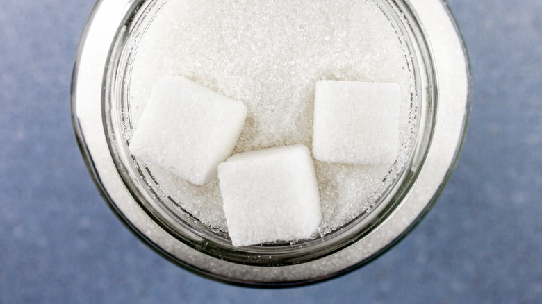 Bowl of sugar against a blue background