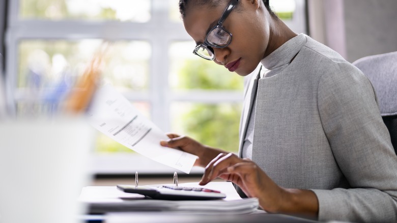 Woman going through paperwork and making calculations