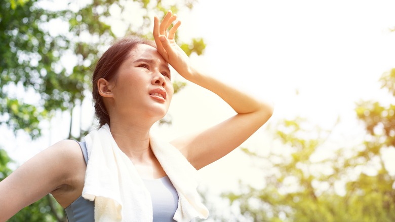 Woman standing under hot sun