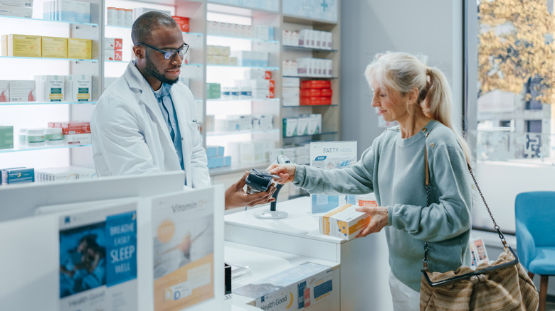 woman paying for her medication at the pharmacy