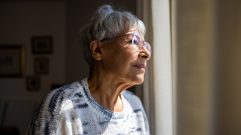 senior woman looking out the window