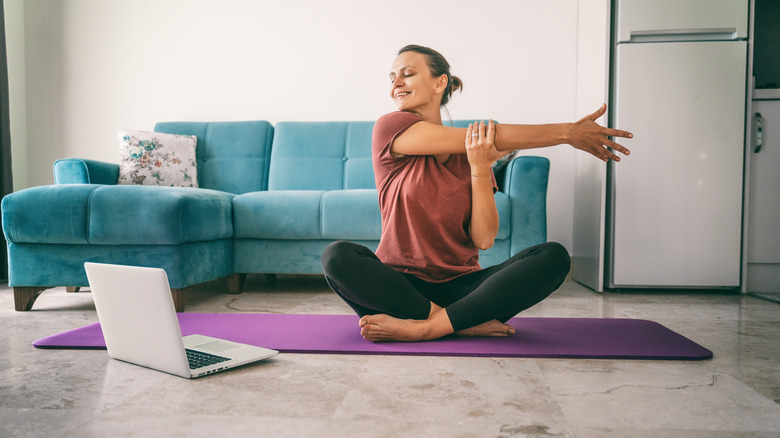 A woman stretches her arm after a workout