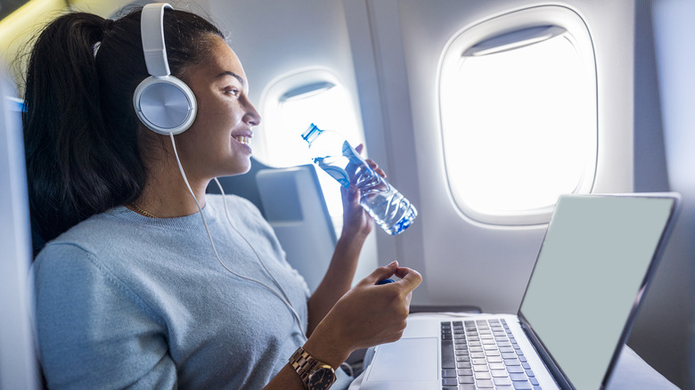 Woman drinking bottled water on a plane