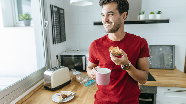 man eating toast in kitchen