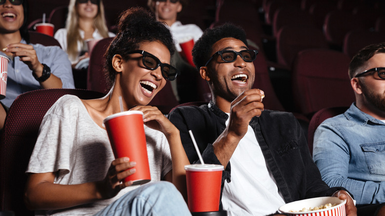Laughing couple watching movie in theater