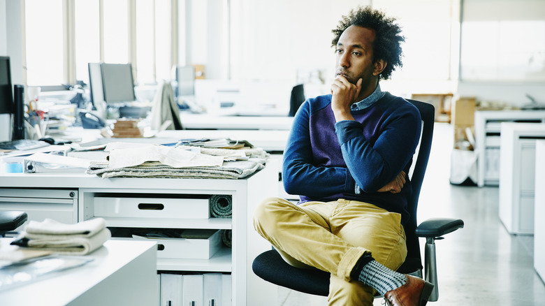 man sitting on office chair thinking