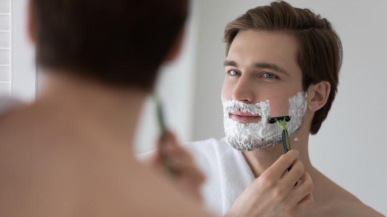 man shaving his beard