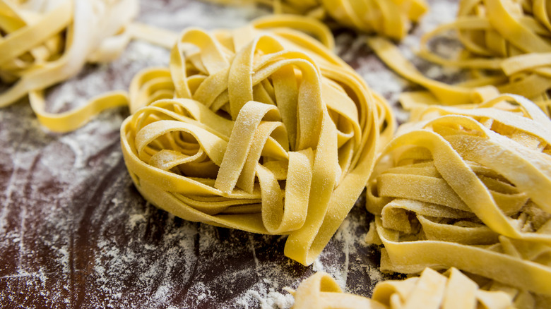 Bunches of egg noodles on a wood surface