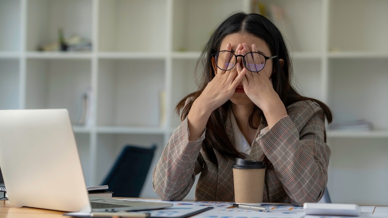 woman sitting at desk feeling stressed