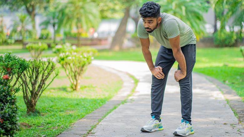 man in park feeling tired while exercising