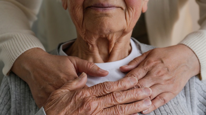 female with arms around elderly woman